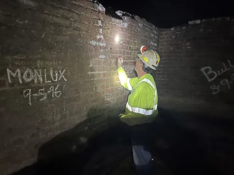 Kyle Ehnes  signs his name to a wall in the old underground blacksmithshop.  
