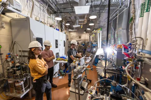 Scientists working on LZ pose in front of the equipment in hard hats and other required PPE
