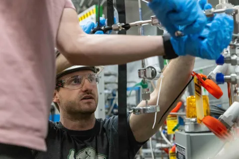 Scientists working on LZ complete hands-on tasks needed to make the experiment run, they are weating rubber gloves and PPE.