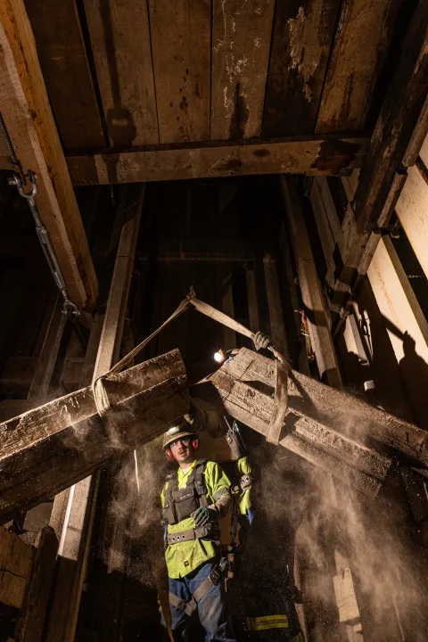 Crews lift a newly cut timber out of the inside of the Yates Shaft