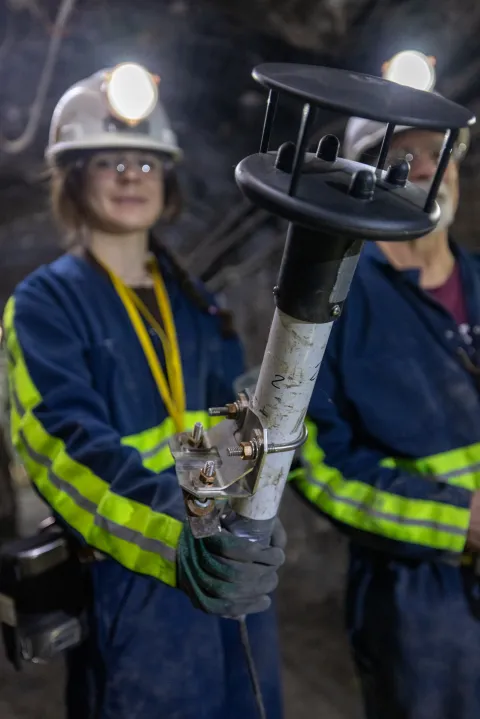 A student holds an underground weather station that monitors air flow at SURF
