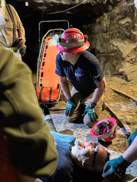 Emergency Response Crews train underground in a mock exercise with a trainer pretending to be injured.