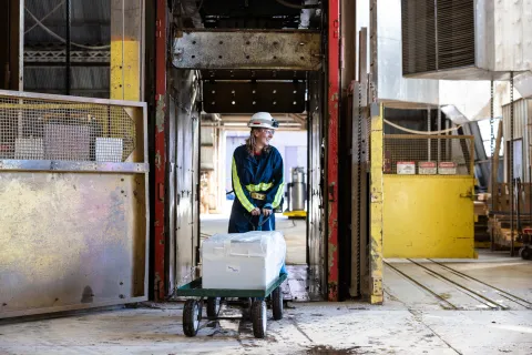 A person with a wagon and boxes of ultra pure copper at the top of the Yates shaft for loading into a car.