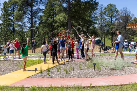 A group of people combine to touch hoops in a jester of togetherness.