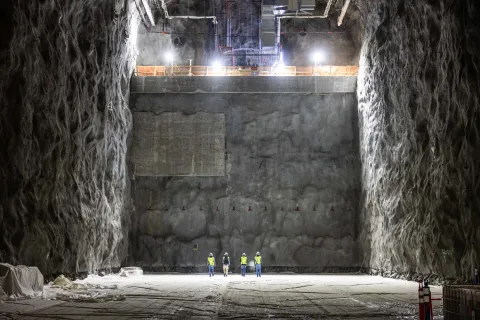 Four students walk to the far side of the North Cavern of the Deep Underground Neutrino Experiment (DUNE) at SURF.