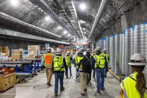 A group walking inside the Central Utility Cavern. 