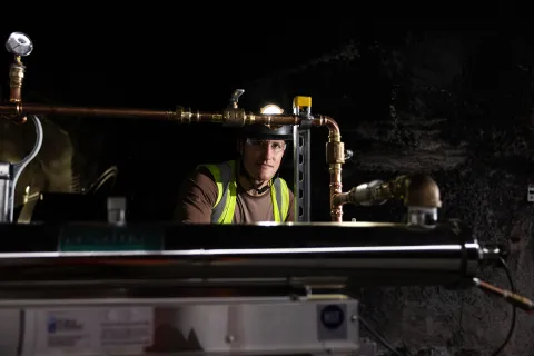 Andrew Brosnahan, a professional engineer at SURF, looks through a set of pipes on the 4850 Level.  