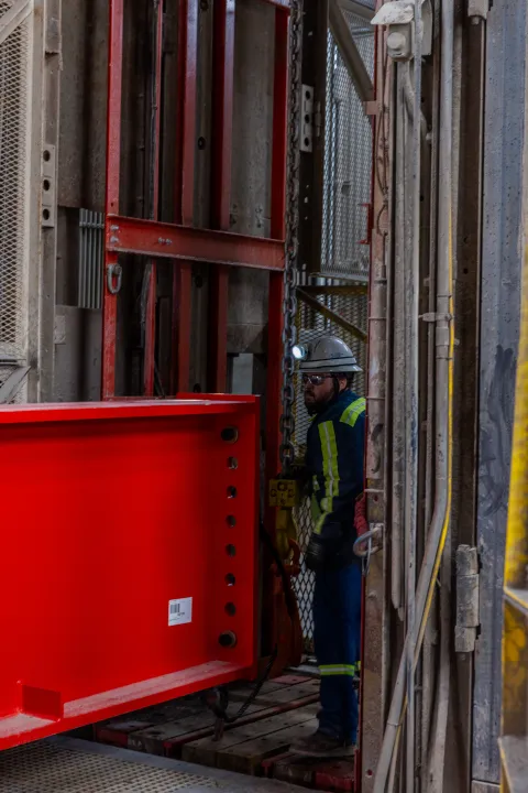 Technicians prep a DUNE cryostat beams for loading into the cage. 