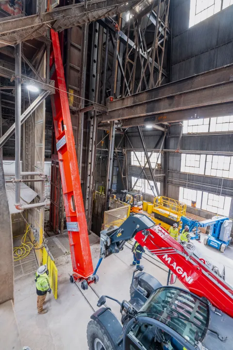 Technicians rig DUNE cryostat beams for loading into the cage - 75% loaded. 