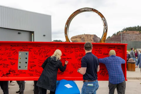 People signing the beam