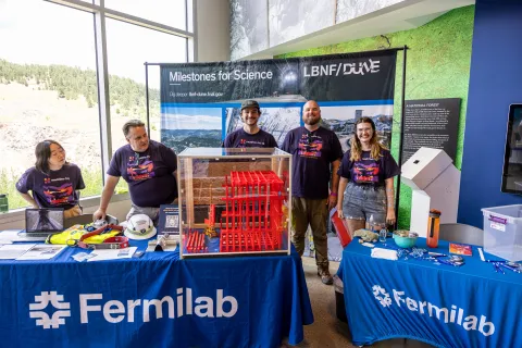 Fermilab volunteers at their table during Neutrino Day 