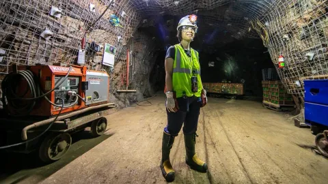 Gina Gibson stands in the middle of an underground drift 