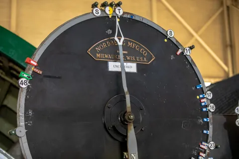 Large dials in front of the hoist operator's station indicate the location of the cages in the shaft.