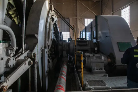 Connecting the grey gear box on the right and the drum's infrastructure on the left is the drum shaft. 