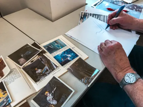 Two hands begin to sketch on a piece of paper