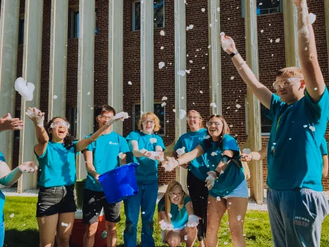 students through bubbles in the air outside