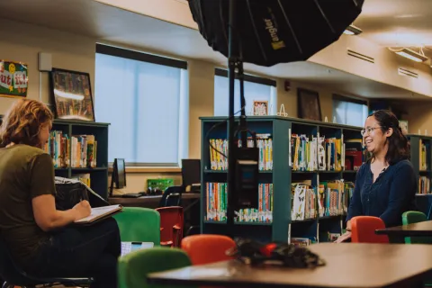 two people talk in a library