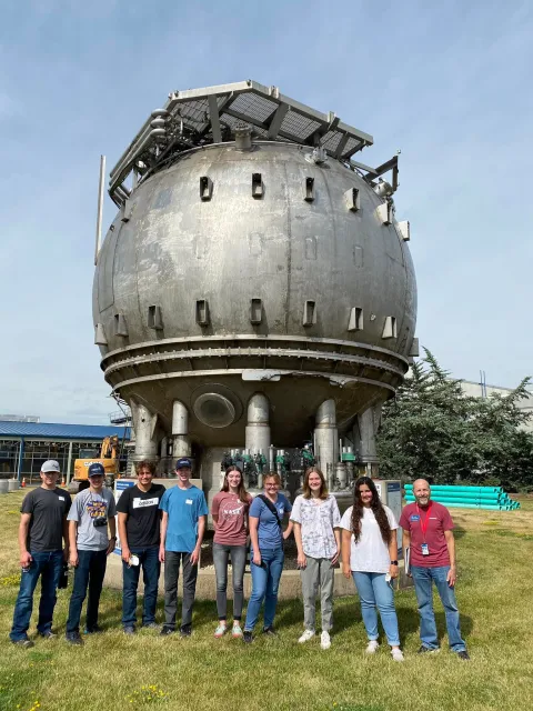 The 2022 Davis-Bahcall Scholars stand in front of the Bubble Chamber at Fermilab in Batavia, Illinois. 