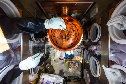 Researchers work on the Majorana Demonstrator’s inner detectors in a glovebox in a cleanroom on SURF’s 4850 Level. Photo by Matthew Kapust 
