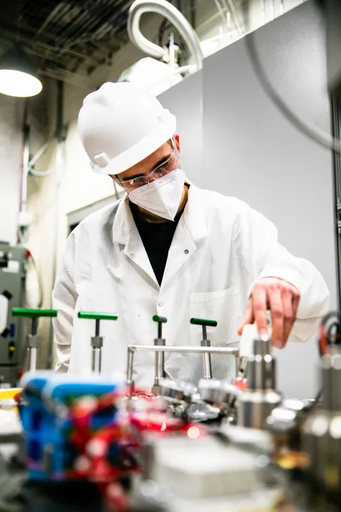 a researcher turns a dial on a complicated testing system