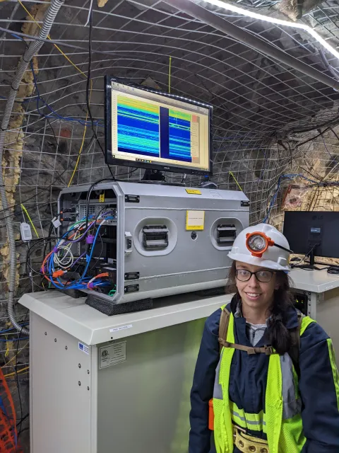 Erin Cunningham stands beside the OpstaSense interrogator installed underground 