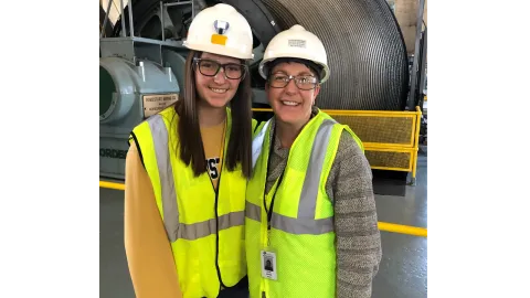 two people. in hardhats smile in the hoistroom