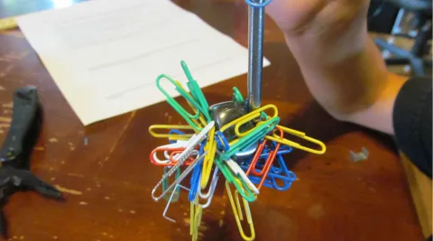 Electromagnet holding paperclips