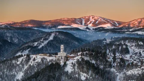 A shot over SURF in the Black Hills showing the Ross Headframe and the Terry Peak ski area on the horizon on a snowy day.