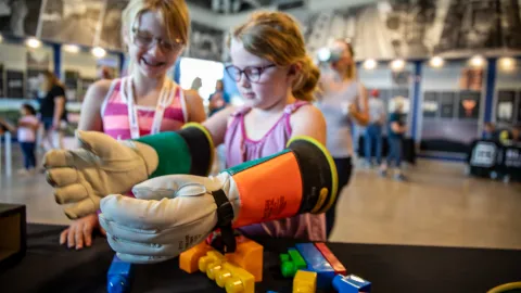 Children play with science learning activities at the Black Hills Energy Booth. 