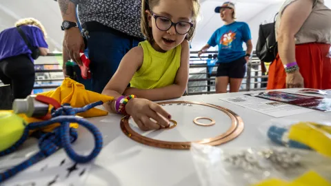 A child engages in science learning activities at Neutrino Day 2024