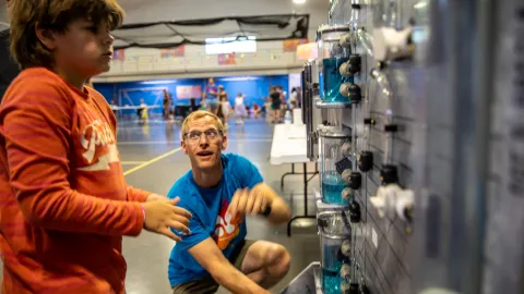 A child takes part in a science learning activity showing a model of the water pumping system at SURF during Neutrino Day 2024. 