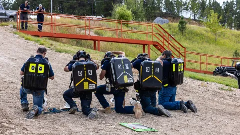 Students wearing PPE and breathing units with gear during the competition