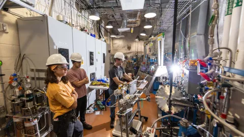 Scientists working on LZ pose in front of the equipment in hard hats and other required  PPE