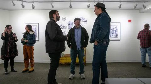 People speak with Marty Two Bulls at the artist reception in the Ruddell Gallery