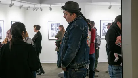 People speak with Marty Two Bulls at the artist reception in the Ruddell Gallery