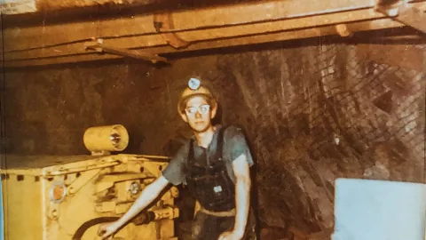 Tom Regan as a young man operating a locomotive underground. 