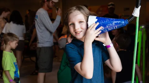 A child enjoys a hands-on learning exhibit with Little Shop of Physics at Neutrino Day 2024 