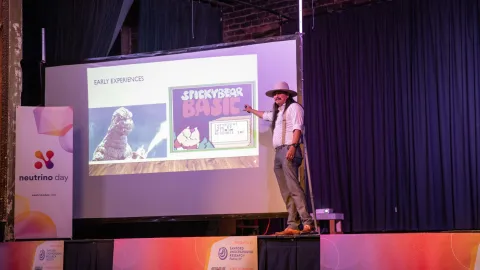 Ian Her Many Horses speaks tot he crowd at Neutrino Day 2024 