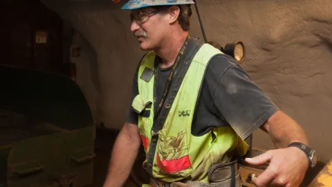 Kip Johnson in full PPE underground his clothes are a little muddy from the work. 