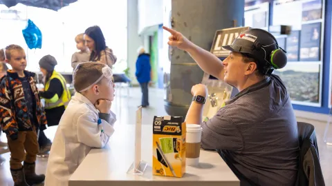 A scientist speaks with a child during a Pi Day Activity at the Sanford Lab Homestake Visitor Center 