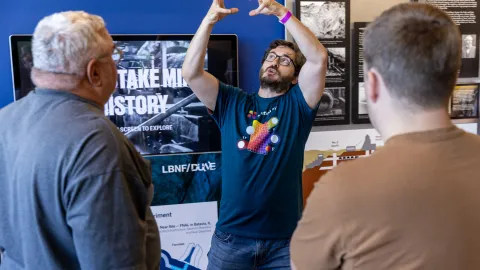One of nearly 200 Neutrino Day volunteers engages the public in a lively description of the science happening at SURF and Fermilab during the 2025 event in Lead, SD.. 