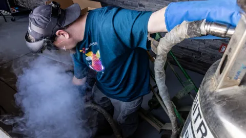 Dr. Douglas Tiedt, a research scientist at SURF, fills a dewar with liquid nitrogen for use in Ice Cream making by the South Dakota Mines Physics Department during the celebration of Neutrino Day 2025 in Lead, SD. 