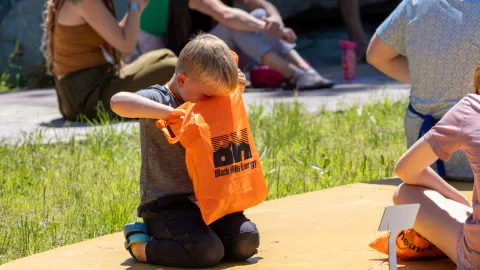 A kid looks into an orange bag