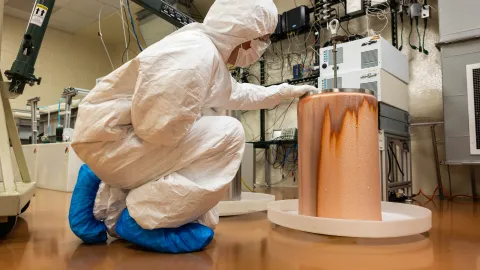 Researchers examine the copper deposited on a mandrel inside the cleanroom at SURF.
