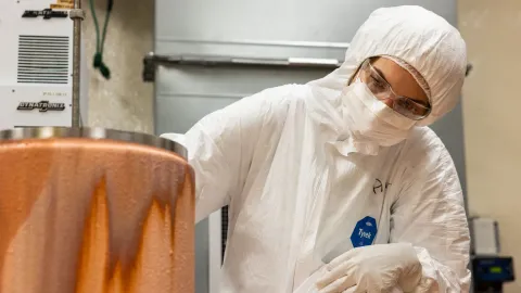 Researchers examine the copper deposited on a mandrel inside the cleanroom at SURF.