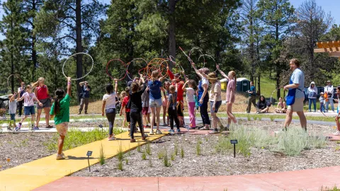 A group of people combine to touch hoops in a jester of togetherness.
