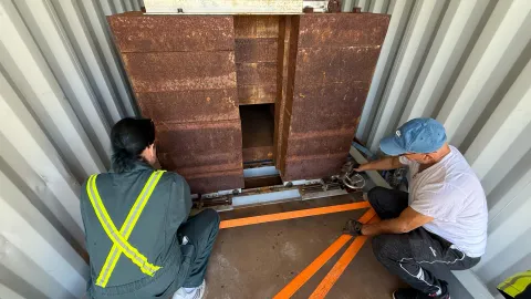 The crew works to load boxes of ultrapure copper into a shipping container with a thick steel box for shielding.
