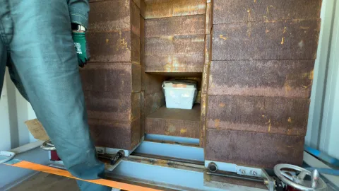 The crew works to load boxes of ultrapure copper into a shipping container with a thick steel box for shielding.