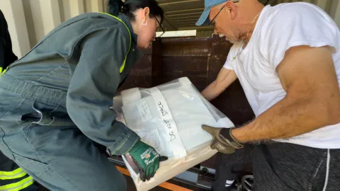 The crew works to load boxes of ultrapure copper into a shipping container with a thick steel box for shielding.