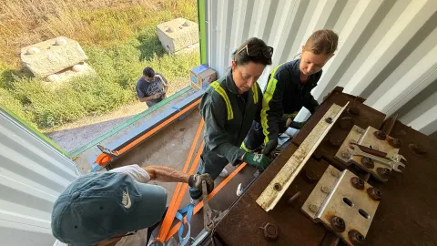 The crew works to load boxes of ultrapure copper into a shipping container with a thick steel box for shielding.